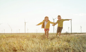 Two children near a wind farm