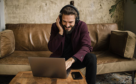 Man wearing headphones working on an laptop